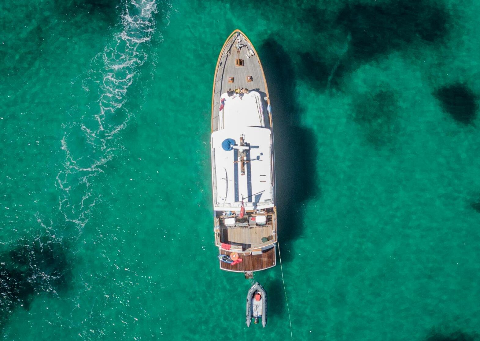 Barco navegando con el fondo del mar turquesa