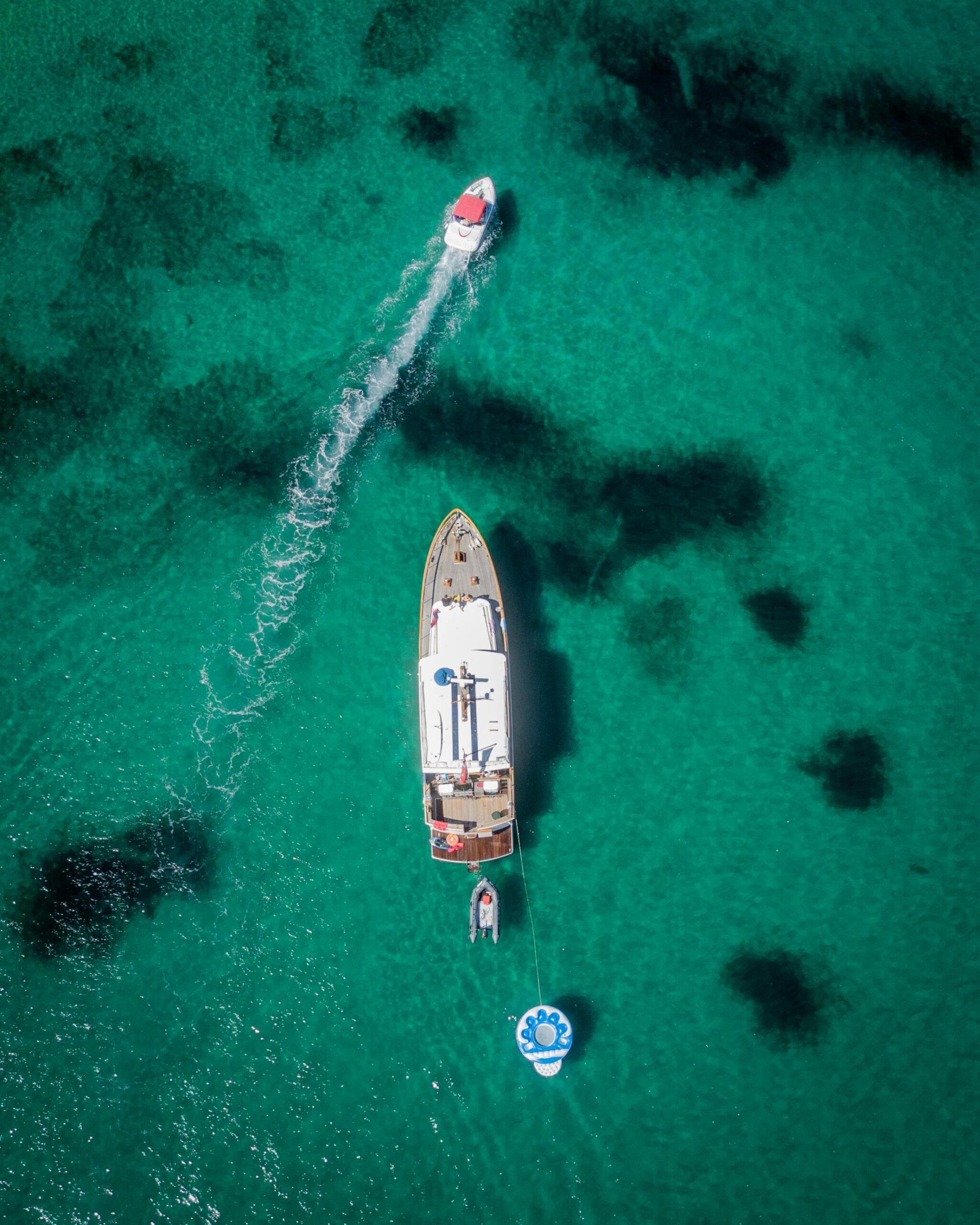 Barco navegando con el fondo del mar turquesa